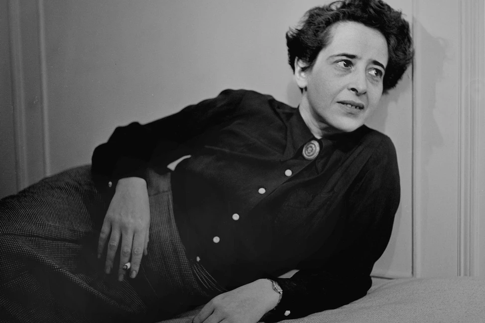 Ханна Арендт на ч/б фотографии: женщина с короткими тёмными волосами в тёмной блузе лежит на диване. Портрет середины XX века.