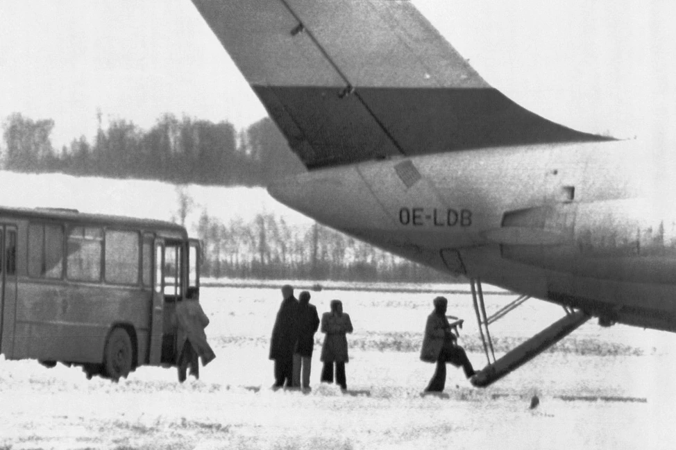 Самолёт с регистрацией OE-LDB, автобус и люди на заснеженном поле венского аэропорта, декабрь 1975