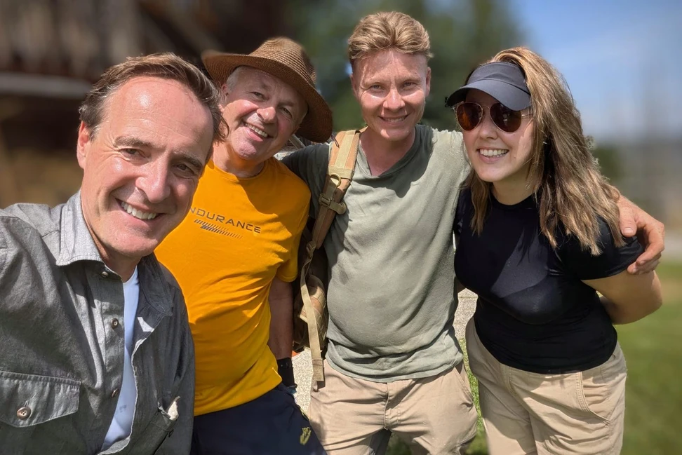 Четверо улыбающихся участников поисков сокровищ позируют на открытом воздухе