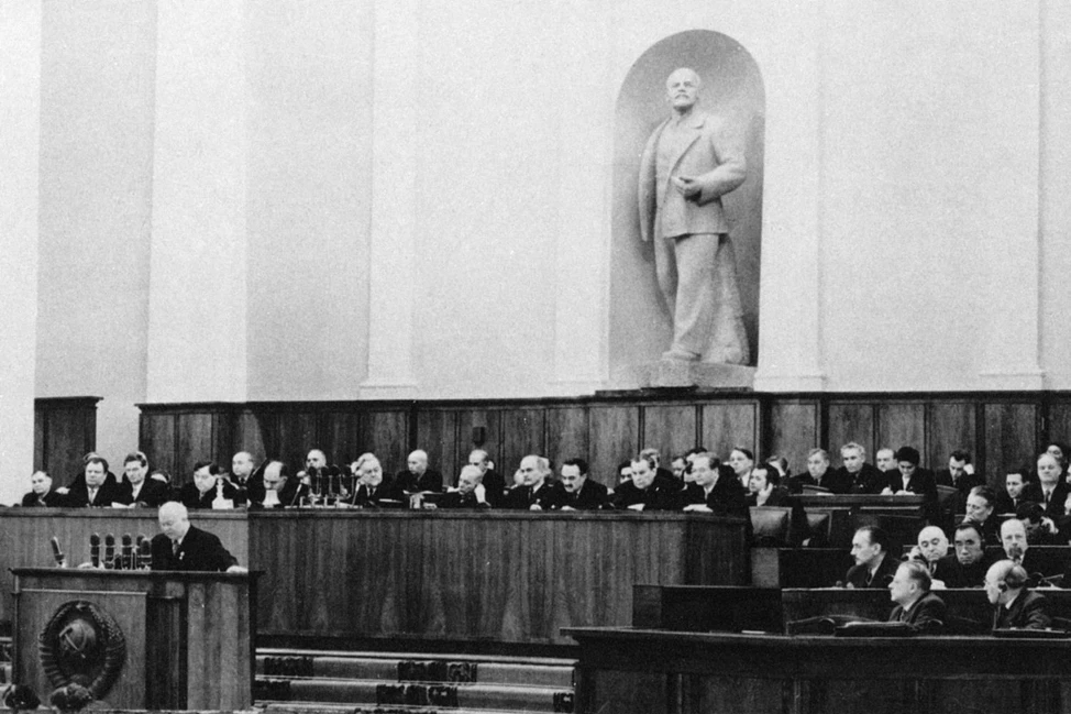 Зал XX съезда КПСС: делегаты за столами, статуя Ленина в нише, трибуна с гербом СССР, 1956 год