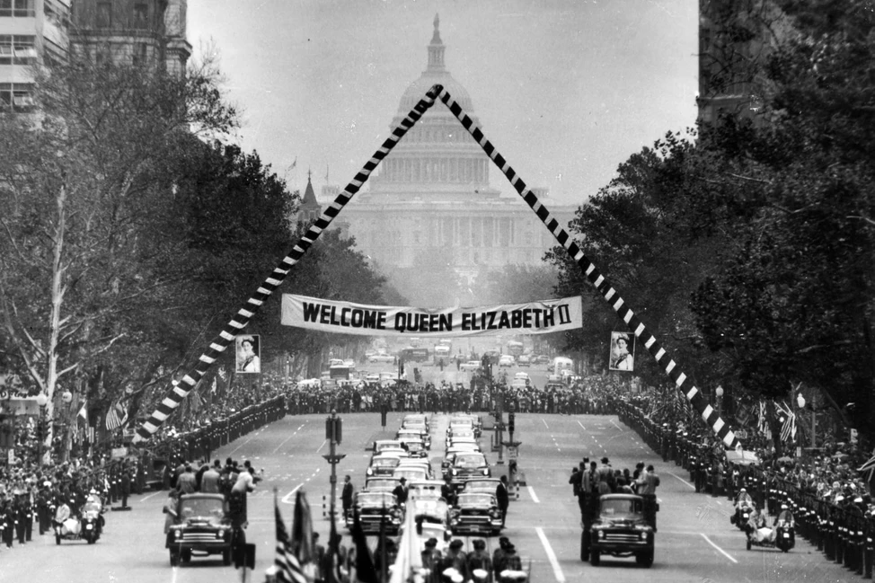 Кортеж Елизаветы II проезжает по улице Вашингтона под баннером Welcome Queen Elizabeth II