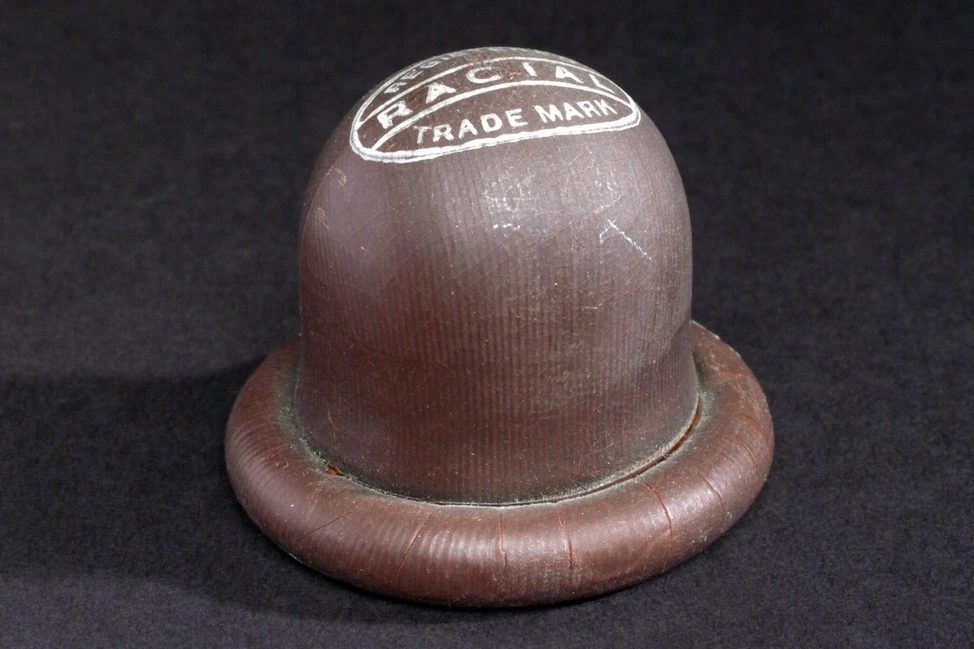 Коричневый резиновый маточный колпачок с надписью RACIAL TRADE MARK на куполе, 1920-е годы