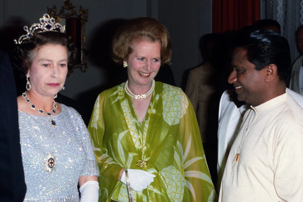 Елизавета II в тиаре и Маргарет Тэтчер рядом с участником встречи