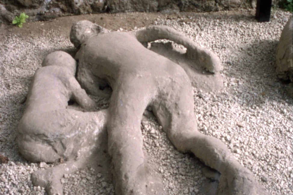 Гипсовые слепки взрослого и ребёнка, лежащих на гравии в Помпеях