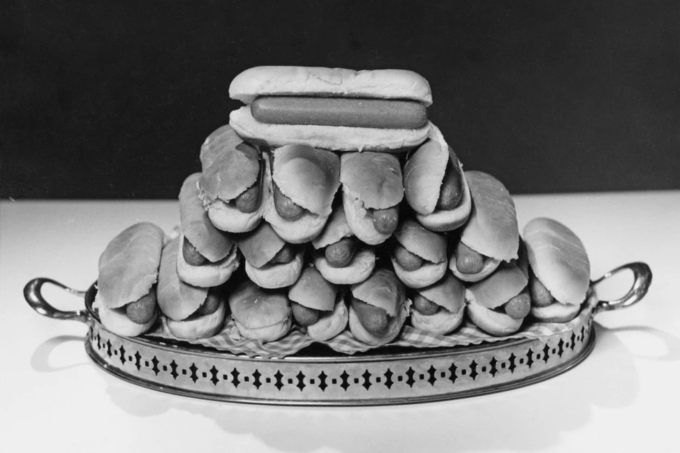 Горка хот-догов на металлическом подносе, чёрно-белый снимок